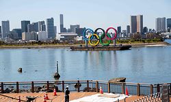 A worker stands at a construction site near the Olympic rings in Tokyo's Odaiba district on March 25, 2020, the day after the historic decision to postpone the 2020 Tokyo Olympic Games. - Japan on March 25 started the unprecedented task of reorganising the Tokyo Olympics after the historic decision to postpone the world's biggest sporting event due to the COVID-19 coronavirus pandemic that has locked down one third of the planet. (Photo by Behrouz MEHRI / AFP)