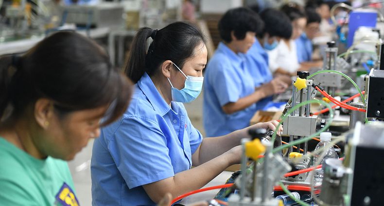 Employees work on an assembly line producing speakers at a factory in Fuyang city, in China's eastern Anhui province on September 30, 2022. (Photo by AFP) / China OUT