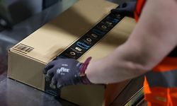 An employee prepares a package for shipment at the Amazon logistics centre in Suelzetal, eastern Germany, on Mai 12, 2021. - The US online sales giant opened the new warehouse in Saxony-Anhalt in August 2020. (Photo by Ronny Hartmann / AFP)