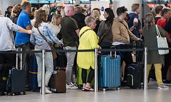 Niederlande, Schiphol: Reisende stehen in der Abflughalle des Flughafens Schiphol Schlange. Am niederländischen Flughafen ist Chaos in diesem Sommer fast Alltag. 
