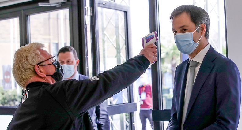 Belgian Prime Minister Alexander De Croo gets his temperature checked during a visit to the vaccination village setup in the Heysel site of the Brussels Expo exhibition halls in Brussels on April 15, 2021. (Photo by OLIVIER HOSLET / BELGA / AFP) / Belgium OUT