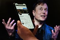 (FILES) In this file photo illustration, a phone screen displays the Twitter account of Elon Musk with a photo of him shown in the background, on April 14, 2022, in Washington, DC. - Twitter on Tuesday sued Elon Musk for breaching the $44 billion contract he signed to buy the tech firm, calling his exit strategy "a model of hypocrisy," court documents showed.
The suit filed in the US state of Delaware urges the court to order the billionaire to complete his deal to buy Twitter, arguing that no financial damages could repair the damage he has caused. (Photo by Olivier DOULIERY / AFP)