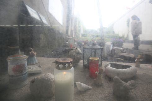 04.05.2020, Nordrhein-Westfalen, Duisburg: An der Loveparade Gedenkstätte brennt eine Trauerkerze hinter einer verschmutzten Glasscheibe. Das Landgericht Duisburg hat den Loveparade-Prozess eingestellt. Bei der Loveparade starben im Sommer 2010 21 junge Menschen in einem Gedränge, mehr als 650 wurden verletzt. Foto: Roland Weihrauch/dpa +++ dpa-Bildfunk +++