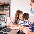 Mother trying to talk with doctor on laptop while watching two kids.Family in isolation covid-19