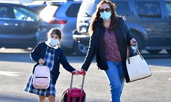 Students arrive for school at St. Joseph Catholic School  in La Puente, California on November 16, 2020, where pre-kindergarten to Second Grade students in need of special services returned to the classroom today for in-person instruction. - The campus is the second Catholic school in Los Angeles County to receive a waiver approval to reopen as the coronavirus pandemic rages on.  The US surpassed 11 million coronavirus cases Sunday, adding one million new cases in less than a week, according to a tally by Johns Hopkins University. (Photo by Frederic J. BROWN / AFP)