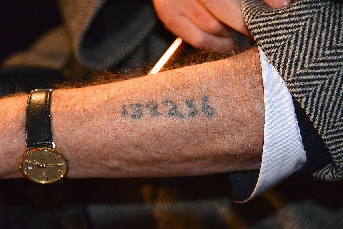 Ein Holocaust-Überlebender zeigt seine Tätowierung bei einer Gedenkveranstaltung in Stockholm im Jahr 2013. 