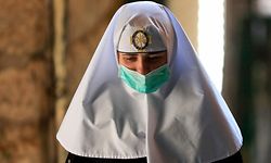 TOPSHOT - A nun walks along the Via Dolorosa (Way of Sorrow), ahead of Easter Sunday service amid the coronavirus disease (COVID-19) outbreak, in Jerusalem's Old City on April 12, 2020. - All cultural sites in the Holy Land are shuttered, regardless of their religious affiliation, as authorities seek to forestall the spread of the deadly respiratory disease. Christians will be prevented from congregating for the Easter service, whether this coming Sunday -- as in the case of Bitar and fellow Catholics -- or a week later on April 19 in the case of the Orthodox. (Photo by Emmanuel DUNAND / AFP)