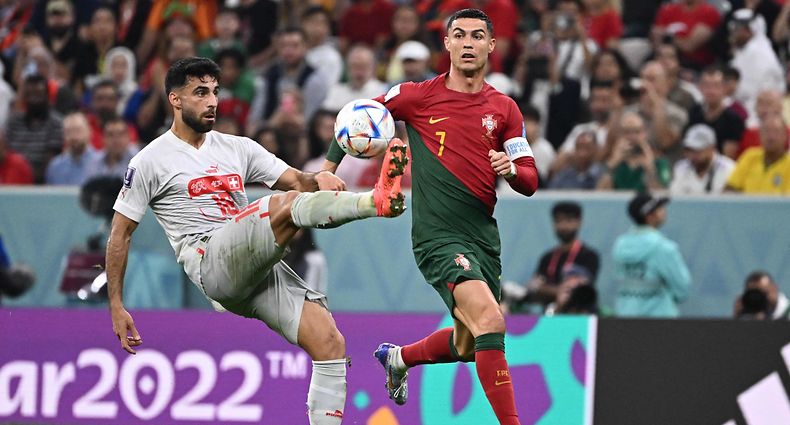 Portugal's forward #07 Cristiano Ronaldo (R) fights for the ball with Switzerland's defender #18 Eray Comert during the Qatar 2022 World Cup round of 16 football match between Portugal and Switzerland at Lusail Stadium in Lusail, north of Doha on December 6, 2022. (Photo by Fabrice COFFRINI / AFP)