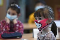 Second-grade pupils wear face masks as they attend school lessons at the Petri primary school in Dortmund, western Germany, on February 22, 2021, amid the novel coronavirus COVID-19 pandemic. - Schools and daycare centres partially reopened in 10 German regions. The impact of school reopenings would be closely watched before deciding the next steps in the pandemic, German Health Minister Jens Spahn said. (Photo by Ina FASSBENDER / AFP)