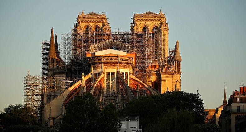 This picture taken on April 14, 2020 shows the Paris' Cathedral Notre Dame at the sunrise on the eve of the first anniversary of the violent fire who destroyed a large part of the monument, on the twenty-nineth day of a lockdown in France to stop the spread of the  COVID-19, (the novel coronavirus). - One year ago, on April 15, 2019, a fire erupted in Notre-Dame Cathedral in Paris, partly destroying the nearly millenium old building and its precious artworks visited by millions of people a year. (Photo by THOMAS COEX / AFP)
