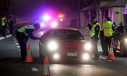 TOPSHOT - Police in the southern New South Wales (NSW) border city of Albury check cars crossing the state border from Victoria on July 7, 2020 as authorities close the border due to an outbreak of COVID-19 coronavirus in Victoria. - Australia on July 7 ordered millions of people locked down in its second-biggest city to combat a surge in coronavirus cases, as nations across the planet scrambled to stop the rampaging pandemic. (Photo by William WEST / AFP)