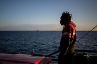 A migrant stands on the deck of the Sea Watch 3 NGO vessel on January 31, 2019 off southeastern Sicily coats, as the ship sails towards Catania to disembark the 47 migrants onboard. - 47 rescued migrants aboard the Sea Watch NGO vessel were expected to disembark in Catania after Italy and France, Germany, Malta, Portugal, Romania and Luxembourg agreed to take them in. The fate of the migrants has been at the centre of a standoff between Italy's far-right Deputy Prime Minister Matteo Salvini -- who has closed the ports to migrants and demanded Europe take its share -- and the German NGO Sea Watch. (Photo by FEDERICO SCOPPA / AFP)