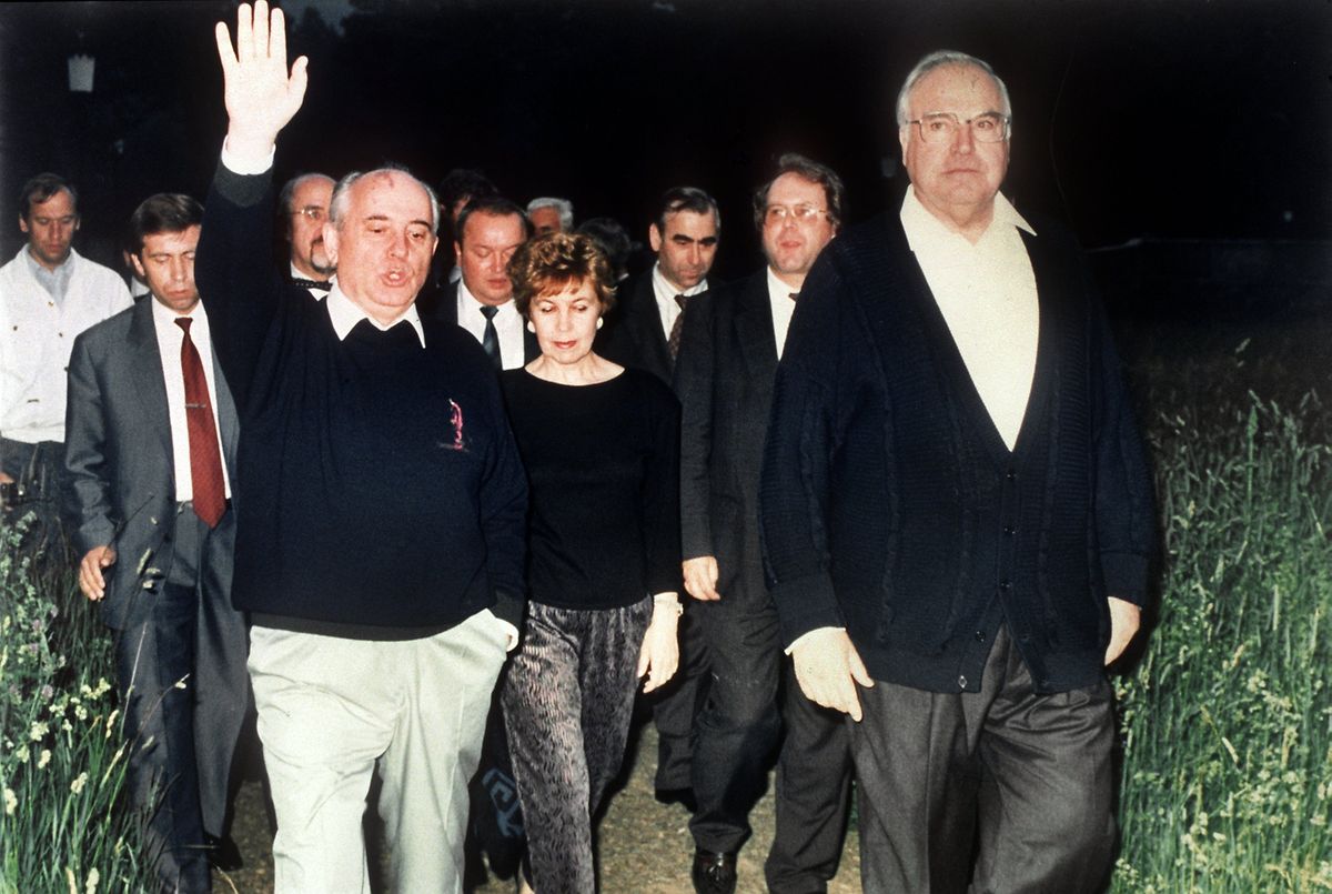 Der damalige Bundeskanzler Helmut Kohl (r) mit dem damaligen sowjetischen Präsidenten Michail Gorbatschow (l) und dessen Frau Raissa während eines Arbeitsbesuch im Jahr 1990 bei einem Spaziergang. 