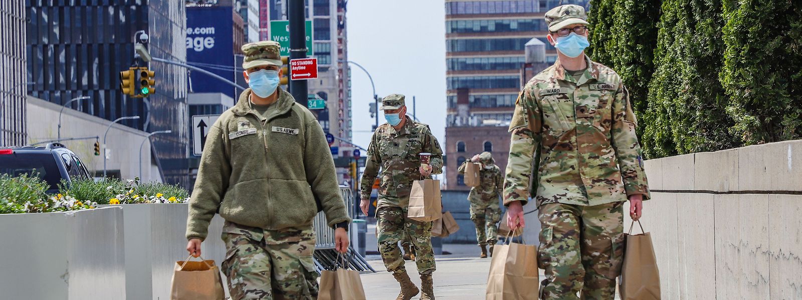 Soldados norte-americanos carregam sacos em frente ao Centro de Exposições Jacob K. Javits, em Nova Iorque, onde foi instalado um hospital temporário. 