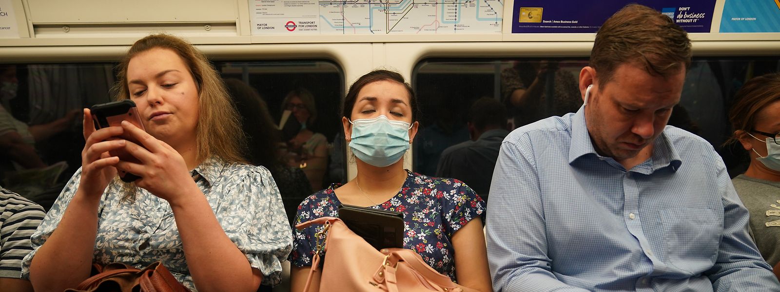 Pendler in einem Londoner U-Bahn-Zug am Montagmorgen, einige noch mit Mund-Nasen-Schutz andere ohne, nachdem die letzten Corona-Maßnahmen aufgehoben wurden.