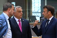 Luxembourg's Prime Minister Xavier Bettel (L), Hungary's Prime Minister Viktor Orban (C) and France's President Emmanuel Macron talk prior to the special meeting of the European Council at The European Council Building in Brussels on May 30, 2022. (Photo by Emmanuel DUNAND / AFP)