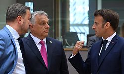 Luxembourg's Prime Minister Xavier Bettel (L), Hungary's Prime Minister Viktor Orban (C) and France's President Emmanuel Macron talk prior to the special meeting of the European Council at The European Council Building in Brussels on May 30, 2022. (Photo by Emmanuel DUNAND / AFP)