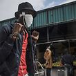 A young man wears a home made mask as a preventive measure as he walks through the busy Wanderers taxi rank in Johannesburg, on March 18, 2020. - African countries have been among the last to be hit by the global COVID-19 coronavirus epidemic but as cases rise, many nations are now taking strict measures to block the deadly illness. (Photo by MARCO LONGARI / AFP)