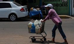 Uma mulher carrega um carro com garrafões de água. A Venezuela vive uma crise económica e social agravada pela covid-19.