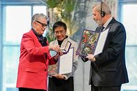 Berit Reiss-Andersen, chair of the Nobel Peace Prize Committee (L), hands over the Nobel Peace Prize diploma and medal to Nobel Peace Prize laureate Maria Ressa of the Philippines (C) and Nobel Peace Prize laureate Dmitry Muratov of Russia (R) during the Nobel Peace prize award ceremony on December 10, 2021 in Oslo. - Investigative journalists Maria Ressa of the Philippines and Dmitry Muratov of Russia won the prestigious award earlier this month for their work promoting freedom of expression at a time when liberty of the press is increasingly under threat. (Photo by Stian Lysberg Solum / NTB / AFP) / Norway OUT
