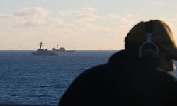 In this handout image courtesy of the US Navy, Seaman Rafael Mendez stands watch aboard the dock landing ship USS Carter Hall (LSD 50) while the guided-missile destroyer USS Oscar Austin (DDG 79) and the guided-missile cruiser USS Philippine Sea (CG 58) transit alongside debris from a high-altitude surveillance balloon in the Atlantic ocean on February 4, 2023. - The United States is recovering debris from the downed Chinese balloon in the Atlantic for analysis by intelligence experts and there is no plan to give the remains back to Beijing, officials said February 6, 2023. Carter Hall is the lead ship in debris recovery efforts led by the Navy, in joint partnership with the US Coast Guard. (Photo by Lt. j.g. Jerry Ireland / US NAVY / AFP) / RESTRICTED TO EDITORIAL USE - MANDATORY CREDIT "AFP PHOTO / HANDOUT / US NAVY Lt. j.g. Jerry Ireland" - NO MARKETING - NO ADVERTISING CAMPAIGNS - DISTRIBUTED AS A SERVICE TO CLIENTS