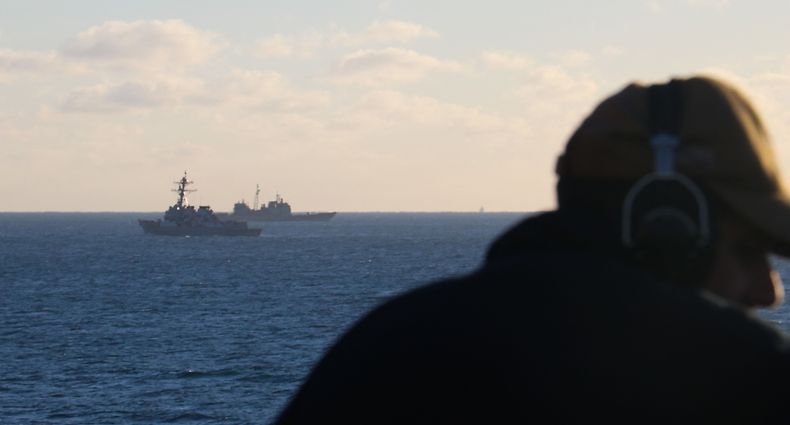 In this handout image courtesy of the US Navy, Seaman Rafael Mendez stands watch aboard the dock landing ship USS Carter Hall (LSD 50) while the guided-missile destroyer USS Oscar Austin (DDG 79) and the guided-missile cruiser USS Philippine Sea (CG 58) transit alongside debris from a high-altitude surveillance balloon in the Atlantic ocean on February 4, 2023. - The United States is recovering debris from the downed Chinese balloon in the Atlantic for analysis by intelligence experts and there is no plan to give the remains back to Beijing, officials said February 6, 2023. Carter Hall is the lead ship in debris recovery efforts led by the Navy, in joint partnership with the US Coast Guard. (Photo by Lt. j.g. Jerry Ireland / US NAVY / AFP) / RESTRICTED TO EDITORIAL USE - MANDATORY CREDIT "AFP PHOTO / HANDOUT / US NAVY Lt. j.g. Jerry Ireland" - NO MARKETING - NO ADVERTISING CAMPAIGNS - DISTRIBUTED AS A SERVICE TO CLIENTS