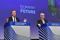 EU Commissioner for the Budget Gunther Oettinger (L) is watched by European Commission President Jean-Claude Juncker (R) as he addresses a press conference to present the EU's next long-term budget, at the European Commission in Brussels, on May 2, 2018. / AFP PHOTO / Emmanuel DUNAND