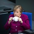 German Chancellor Angela Merkel holds a protective face mask during a session at the Bundestag (Germany's lower house of parliament) in Berlin on March 25, 2021, ahead of a EU summit. (Photo by STEFANIE LOOS / AFP)