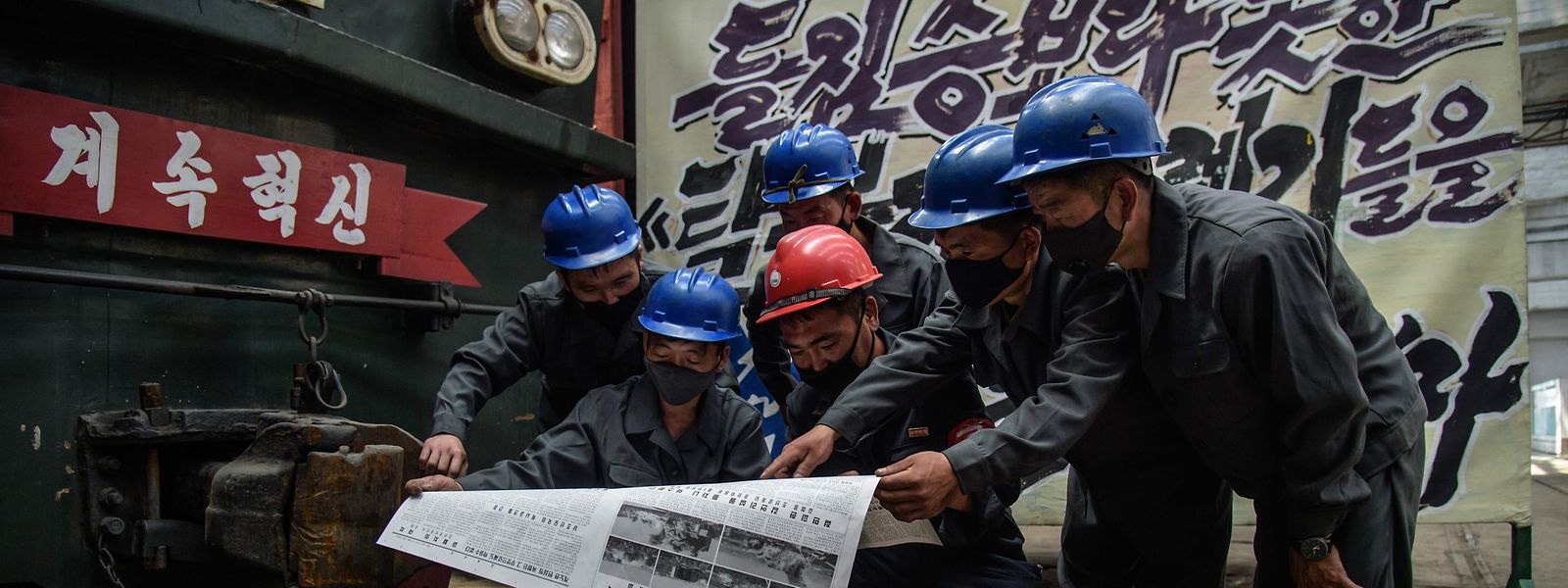 Trabalhadores da Kim Jong Thae Electric Locomotive Complex lêem no jornal do regime as mais recentes notícias sobre a tensão entre as duas coreias.