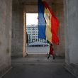 (FILES) In this file photo taken on October 08, 2013 a woman walks walk under The Triumph Arch next to a Moldovan flag on Stefan Cel Mare street in Chisinau. - Moldova's acting president Pavel Filip on June 9, 2019 dissolved parliament and called snap elections, as a political crisis rocks the ex-Soviet country. Filip signed a decree dissolving parliament and calling snap elections for September 6 after the Constitutional Court earlier on June 9, 2019 suspended pro-Russia president Igor Dodon and named Filip, who is the acting prime minister, as acting president. (Photo by Daniel MIHAILESCU / AFP)