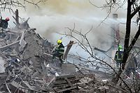 Firefighters try to extinguish a fire after a missile hit a building on the outskirts of Kharkiv on April 12, 2022. (Photo by SERGEY BOBOK / AFP)