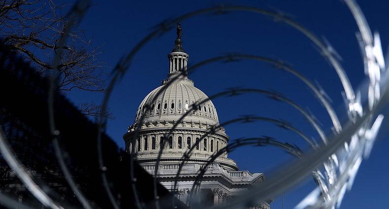 (FILES) In this file photo taken on March 05, 2021, security fencing surrounds the US Capitol on March 5, 2021, in Washington, DC. - On January 6, 2021 they descended upon Washington, DC in the thousands, gathering to protest the result of a presidential election they still claim was "rigged." The US Capitol came under attack, leaving the country wounded. The world watched live, aghast, as the citadel of American democracy came under assault. During the next few months, two competing narratives would arise. Trump supporters claim it was a peaceful protest against a "stolen" election. Police officers who fought with the mob, Democratic lawmakers and even some Republicans called it "terrorism." (Photo by OLIVIER DOULIERY / AFP)