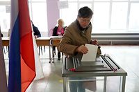 Uma residente de Mariupol deposita o seu boletim de voto na urna a 27 de setembro.