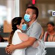 BOGOTA, COLOMBIA - March 12:  A couple hug as they wear face masks around the International airport "u201cEl Dorado"u201d on March 12, 2020 in Bogota, Colombia. The World Health Organization declared a global pandemic as the coronavirus rapidly spreads across the world. Colombian President Ivan Duque declared a health emergency to contain an outbreak of coronavirus, suspending public events with more than 500 people. (Photo by Daniel Munoz/VIEWpress vía Getty Images)