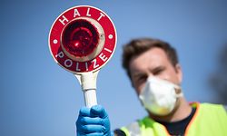 ARCHIV - 10.04.2020, Niedersachsen, Nordhorn: Ein mit Atemschutzmaske ausgerüsteter Beamter der Bundespolizei hält eine Kelle ("Halt Polizei") an der Grenze zu den Niederlanden. Foto: Friso Gentsch/dpa +++ dpa-Bildfunk +++