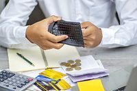 poor Asian man hand open empty purse looking for money having problem bankrupt broke after credit card payday