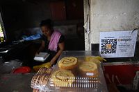 A woman is seen in a store where bitcoins are accepted in El Zonte, La Libertad, El Salvador on September 4, 2021. - The Congress of El Salvador approved in June a law that will make bitcoin legal tender in the country from September 7, with the aim of boosting its economy although analysts warn of a negative impact. (Photo by MARVIN RECINOS / AFP)