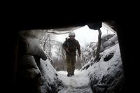 TOPSHOT - An Ukrainian Military Forces serviceman walks along a snow covered trench on the frontline with the Russia-backed separatists near Zolote village, in the eastern Lugansk region, on January 21, 2022. - Ukraine's Foreign Minister Dmytro Kuleba on January 22, 2022, slammed Germany for its refusal to supply weapons to Kyiv, urging Berlin to stop "undermining unity" and "encouraging Vladimir Putin" amid fears of a Russian invasion. (Photo by Anatolii STEPANOV / AFP)