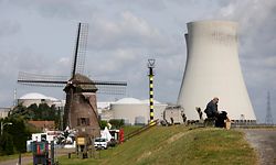 A windmill is seen near the Doel nuclear plant in northern Belgium August 22, 2012. GDF Suez's Belgian unit, Electrabel, will find it difficult to prove its Doel 3 nuclear reactor is safe enough to operate, Belgian regulator FANC said lsat week, raising the prospect that the 30-year-old unit could stay shut for good. REUTERS/Francois Lenoir (BELGIUM - Tags: BUSINESS ENERGY ENVIRONMENT)