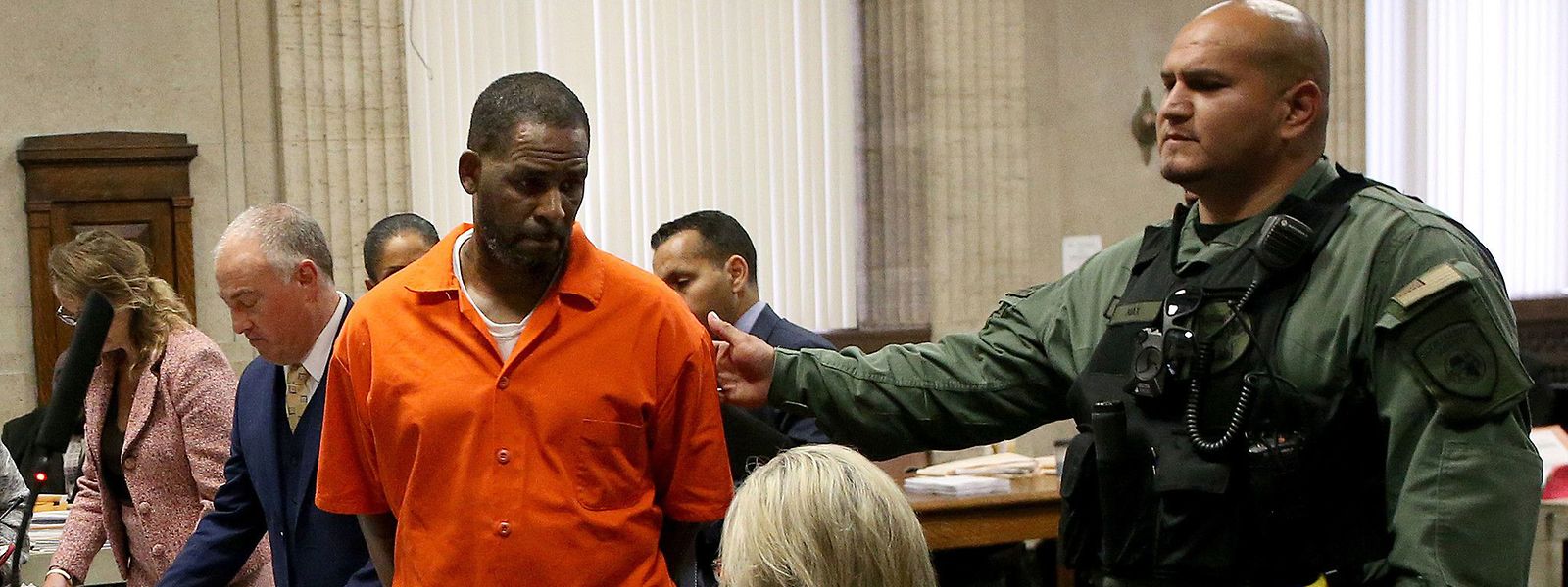O músico R. Kelly de fato prisional laranja numa sessão em tribunal.