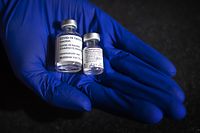 11.03.2021, Großbritannien, London: Ein Mitarbeiter zeigt die ersten verabreichten Ampullen mit den Corona-Impfstoffen von Astrazeneca (l) und Biontech/Pfizer, die Teil einer neuen COVID-19-Austellung im Science Museum sein werden. Foto: Victoria Jones/PA Wire/dpa +++ dpa-Bildfunk +++