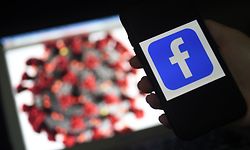 (FILES) In this file photo taken on March 24, 2020 a Facebook logo is displayed on a mobile phone screen next to a coronavirus COVID-19 illustration in Arlington, Virginia. - Facebook on April 29, 2020 reported a sharp jump in usage as the global pandemic unfolded, in a quarterly update that sparked a rally in shares of the social network despite its warning of turbulence in the coming months. (Photo by Olivier DOULIERY / AFP)