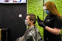 A hairdresser cuts the hair of a client at a hairdressing salon in Bratislava on May 6, 2020, amid the novel coronavirus COVID-19 pandemic. - The Slovakian government is easing restrictions because of the low number of new coronavirus infections. Slovakia reopens from May 6, 2020 shops and most service providers, restaurants - for outdoor seating only - as well as museums and galleries. (Photo by VLADIMIR SIMICEK / AFP)