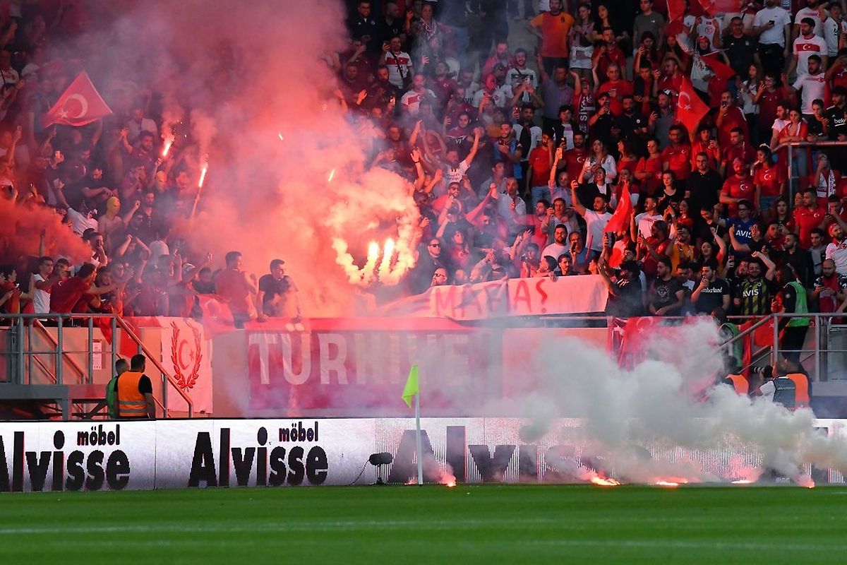 Les supporters turcs lancent des feux de Bengale sur le terrain.