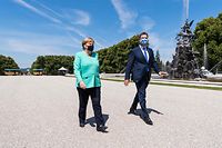 German Chancellor Angela Merkel and Bavaria's State Premier and leader of the Bavarian Christian Social Union (CSU) Markus Soeder wear face masks as they walk to the castle on Herrenchiemsee island, Bavaria, on July 14, 2020. - Chancellor Angela Merkel will attend the Bavarian cabinet meeting in the Mirror Gallery of the New Palace of Herrenchiemsee. (Photo by Peter Kneffel / POOL / AFP)