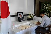A Japanese national signs the condolence book for the late former Japanese prime minister Shinzo Abe at Japan's embassy in Manila on July 11, 2022. (Photo by JAM STA ROSA / AFP)