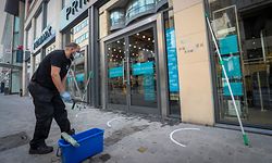 A worker cleans windows of a clothes shop with social distancing markings on the pavement outside in the rue Neuve - Nieuwstraat shopping street in the city centre of Brussels, on May 9, 2020, as Belgium prepares to ease measures following eight weeks of lockdown aimed at curbing the spread of the COVID-19 pandemic, caused by the novel coronavirus. - Shops will be allowed to reopen and more people return to work in Belgium starting May 11, 2020. (Photo by VIRGINIE LEFOUR / BELGA / AFP) / Belgium OUT