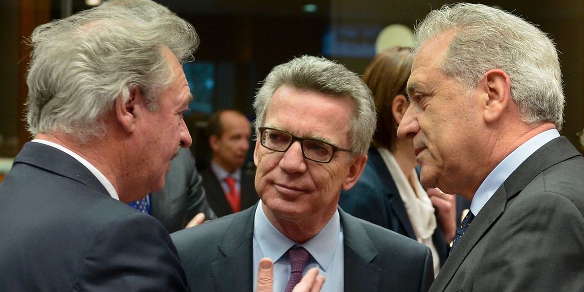 Jean Asselborn (esq.), à conversa com o ministro do Interior alemão Thomas de Maiziere (centro) e o comissário para as Migrações, Dimitris Avramopoulos