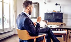 bearded business man reading on mobile in home office