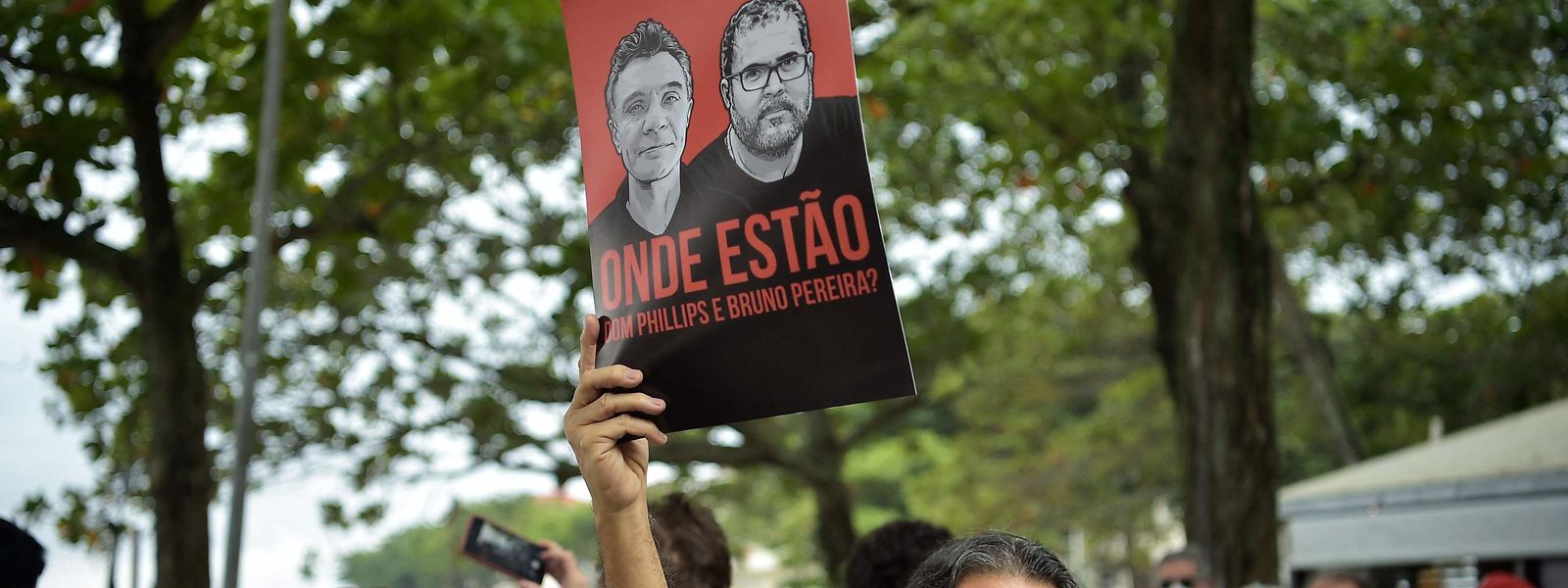 Um manifestante ergue um cartaz com os rostos de Dom Phillips e Bruno Pereira na praia de Copacabana, no Rio de Janeiro, Brasil.